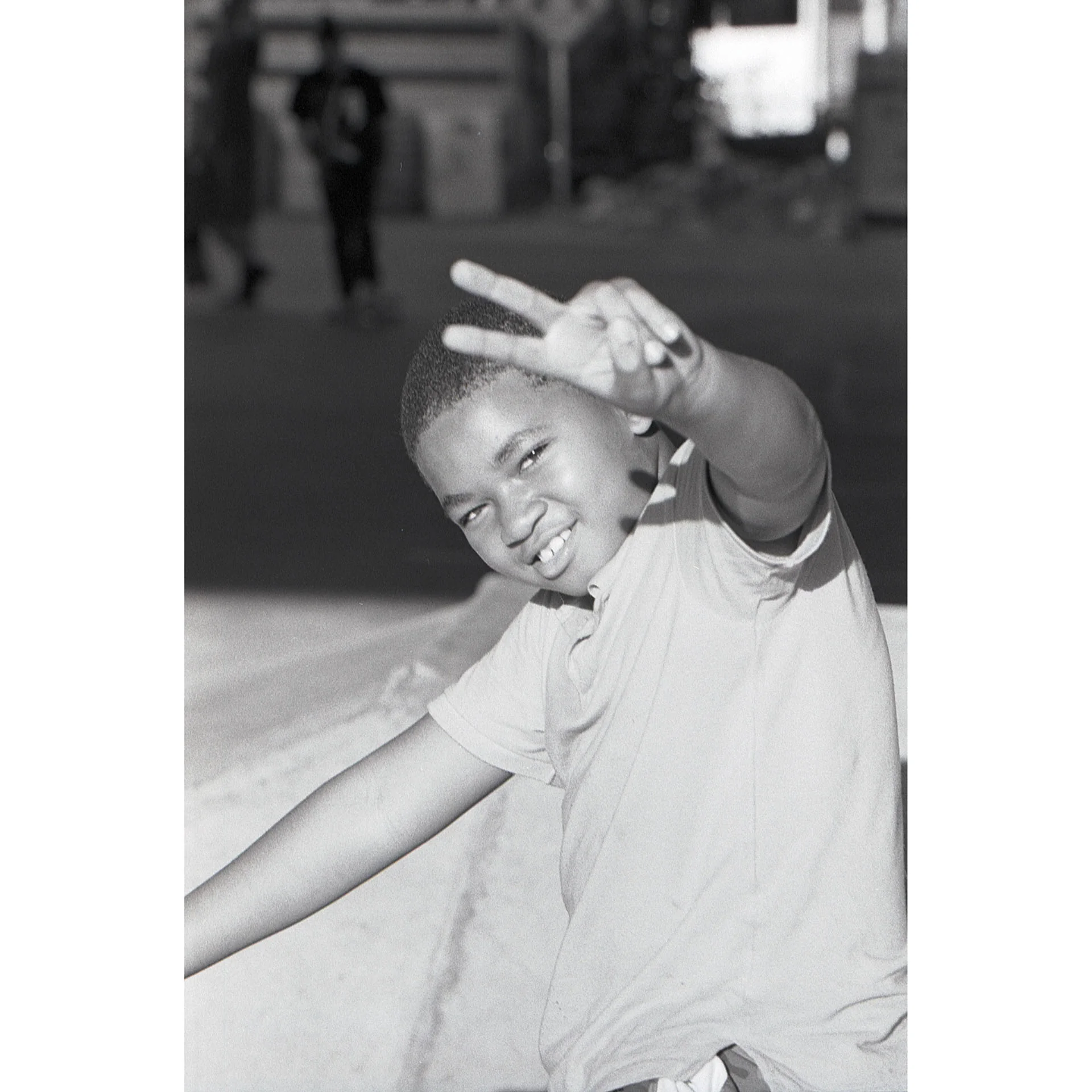 Young boy giving the peace sign while sitting on his bike at National DIY. Photo by Dylan Shanahan.